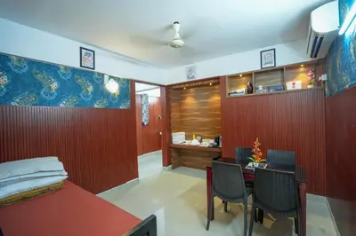 a bedroom with a bed and a table and chairs at Mayflower Family Lounge -Cochin Airport in Nedumbassery