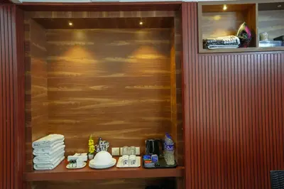 a room with a wooden wall and a shelf with towels at Mayflower Family Lounge -Cochin Airport in Nedumbassery