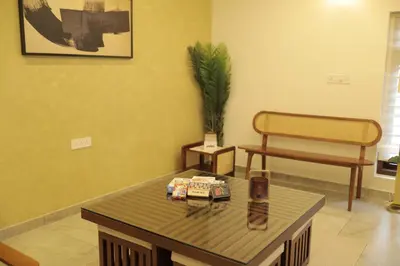 a living room with a coffee table and a plant at Kaayal Experience - Entire Home in Kozhikode in Kozhikode