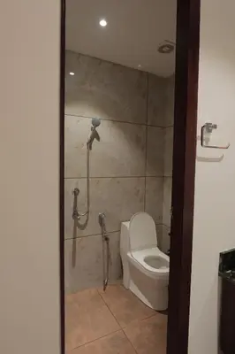 a bathroom with a toilet and a shower at Kaayal Experience - Entire Home in Kozhikode in Kozhikode