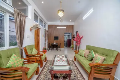 a living room with green couches and a table at Spring Fields in Coimbatore