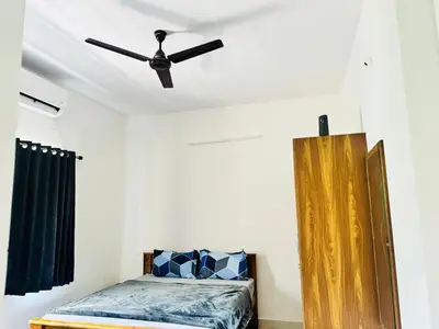 a bedroom with a ceiling fan and a bed at Jayasviinn Coorg in Virajpet