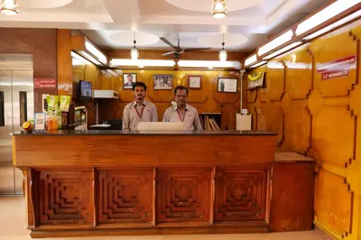 two men standing at a bar in a restaurant at Sakthi Hotel in Pollāchi