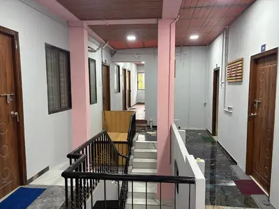 a hallway of a building with pink pillars and stairs at AJ GrandInn in Podanūr