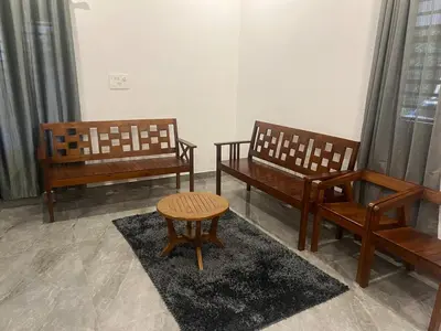 three benches and a table in a room at Mynakam - A peaceful escape in Vythiri