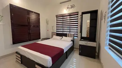 a bedroom with a bed and a large window at Cardamom cottage in Periya