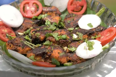a bowl of food with tomatoes and vegetables on it at Cardamom cottage in Periya