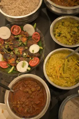 a table topped with bowls of different types of food at Cardamom cottage in Periya