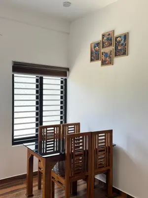 a dining room table with two chairs and a window at VGK Residency in Wayanad