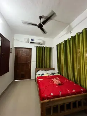 a bedroom with a bed and a ceiling fan at Raya Casa Couple Suite 101 in Guruvāyūr