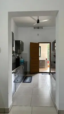 a large kitchen with a large open door at Snehanilayam in Trichūr