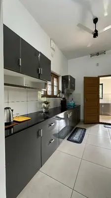 a kitchen with stainless steel cabinets and a ceiling at Snehanilayam in Trichūr