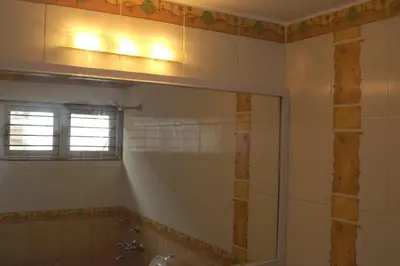 a bathroom with a shower and a sink and a mirror at Aarroh villa in Coonoor