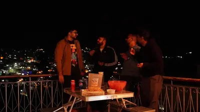 a group of men standing on a balcony at night at Aarroh villa in Coonoor