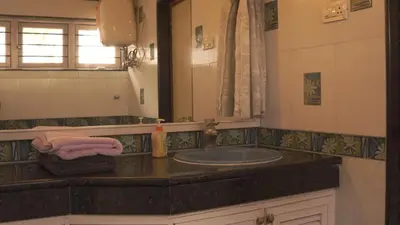 a bathroom with a sink and a mirror at Aarroh villa in Coonoor