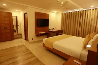 a hotel room with a bed and a television at Devalokam Edappal in Edappāl