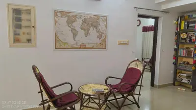 a room with chairs and a table and a map on the wall at The Mangosteen Homestay in Kodanad