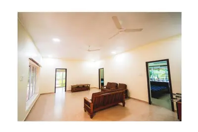 a living room with a couch and a ceiling fan at Vetha farm in Aravakkurichchi