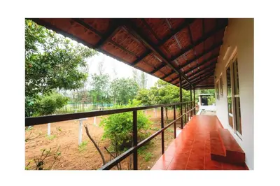 a balcony of a house with a view of a yard at Vetha farm in Aravakkurichchi