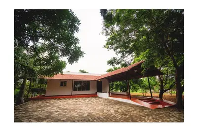 a house with a large driveway in front of it at Vetha farm in Aravakkurichchi