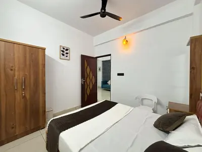 a bedroom with a bed and a ceiling fan at Lakshmi Home in Trichūr