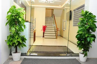 a hallway with two potted plants and a staircase at Vgrand in Ooty