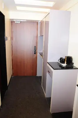 a small room with a door and a kitchen at Vgrand in Ooty