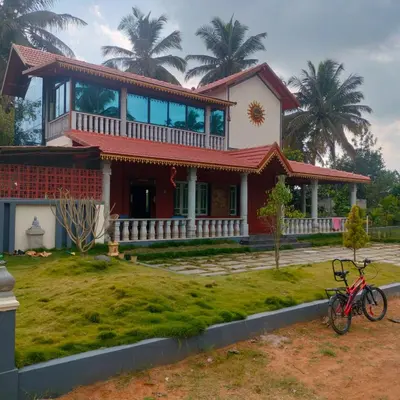a house with a bike parked in front of it at MVR Home Stay in Seringapatam
