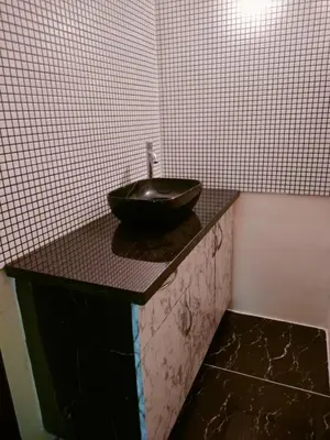 a bathroom with a black bowl sink on a counter at MVR Home Stay in Seringapatam