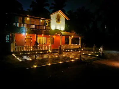 a house with a clock on top of it at night at MVR Home Stay in Seringapatam