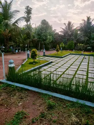 a fence in front of a park with palm trees at MVR Home Stay in Seringapatam