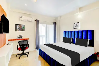 a bedroom with a bed and a desk and a chair at Collection O City Bus Station Mysuru in Mysore