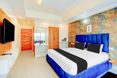 a bedroom with a large bed and a tv at Collection O City Bus Station Mysuru in Mysore