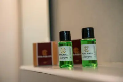 two bottles of green liquids sitting on a shelf at Royal Plaza Glitz Inn in Kozhikode