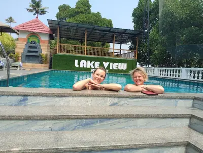 two girls laying on the side of a swimming pool at Lake view Resort cherai in Cherai Beach