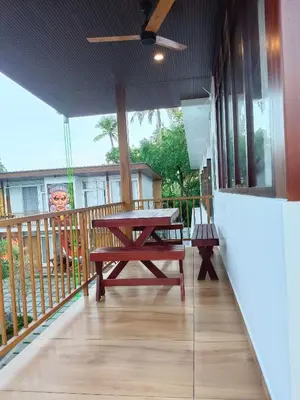 a wooden deck with a picnic table on a balcony at Lake view Resort cherai in Cherai Beach