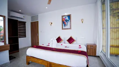 a bedroom with a large bed with red flowers on it at Lake view Resort cherai in Cherai Beach