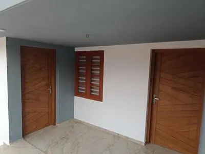 a room with two wooden doors and a wall at La- casona in Kottayam
