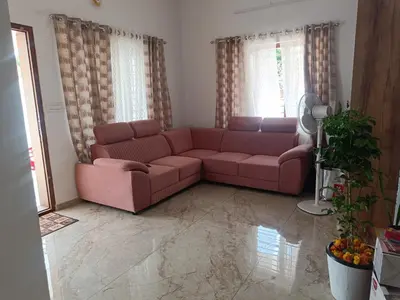a living room with a pink couch in front of two windows at La casona in Kottayam