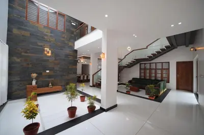 a living room with potted plants and a staircase at Village Pavilion in Tellicherry