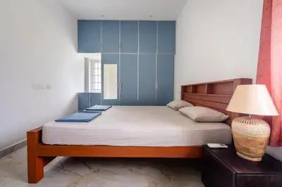 a bedroom with a large bed with blue cabinets at Meenakshi residency in Alāndurai