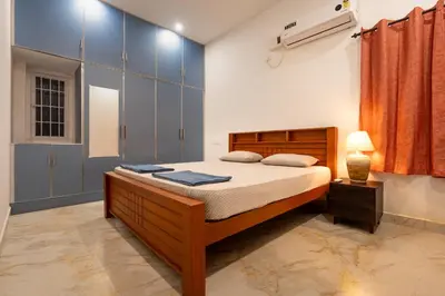 a bedroom with a bed with blue cabinets and a lamp at Meenakshi residency in Alāndurai