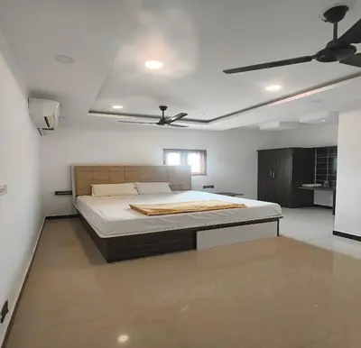 a bedroom with a bed and a ceiling fan at The Canalway Inn in Pollāchi