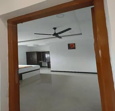 a view of a living room with a ceiling fan at The Canalway Inn in Pollāchi