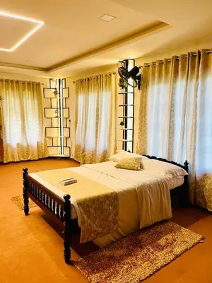 a bedroom with a large bed in front of windows at Joevilla-1BHK Near Kottiyoor in Kelakam