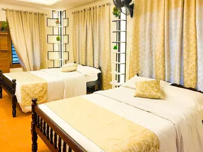 a bedroom with two beds and curtains at Joevilla-1BHK Near Kottiyoor in Kelakam