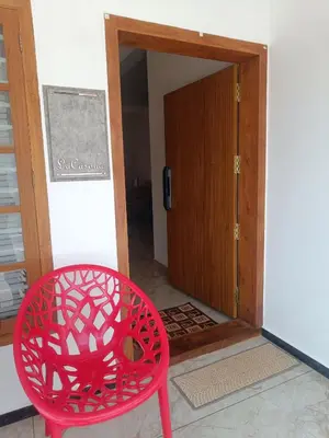 a red chair sitting in front of a door at La-Casona in Kottayam