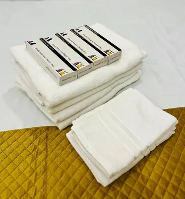 a stack of white towels sitting on top of a bed at Joevilla - 3BHK Near Kottiyoor in Kelakam