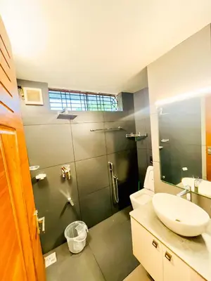 a bathroom with a shower with a sink and a toilet at Joevilla - 3BHK Near Kottiyoor in Kelakam