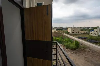a door to a balcony with a view of a street at Cross Roads Inn in Coimbatore